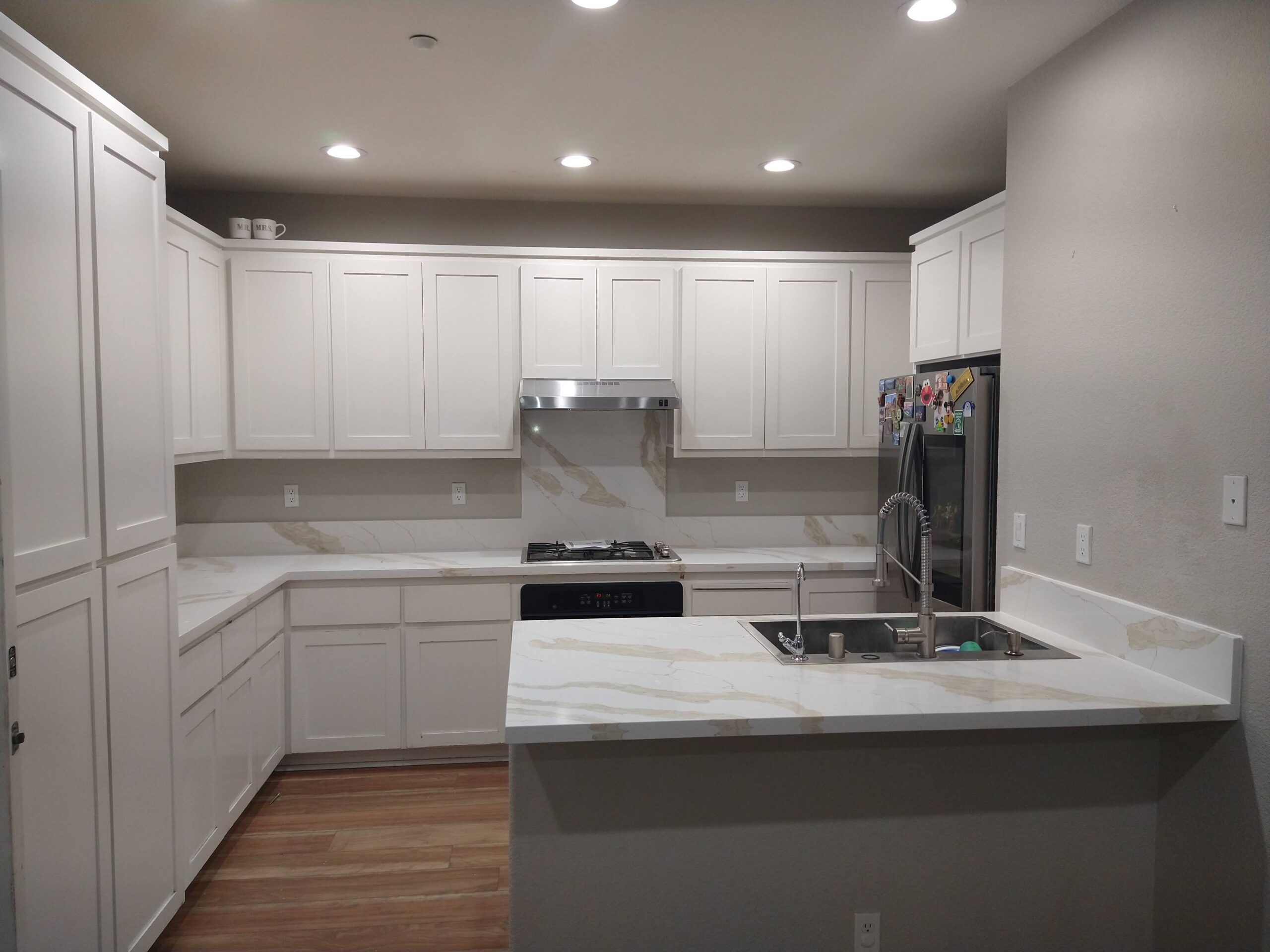 Top quartz countertop installation near me – modern Bay Area kitchen with waterfall peninsula and Calacatta pattern
